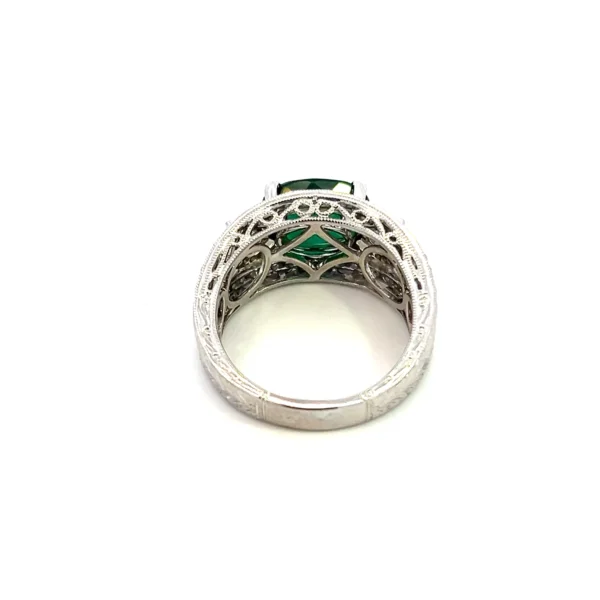 One estate 14 karat white gold ring with an oval faceted green tourmaline weighing 2.95 carats and round brilliant accent diamonds weighing 0.55 carat total weight with a figure eight design in the shoulders and a carved wheat leaf design in the remainder of the band