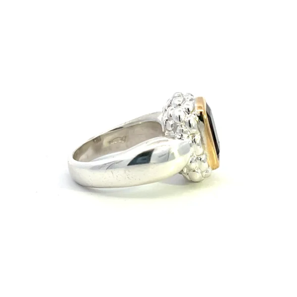 One estate sterling silver fashion ring with an elongated cushion-shaped faceted smoky quartz in an 18 karat yellow gold bezel setting