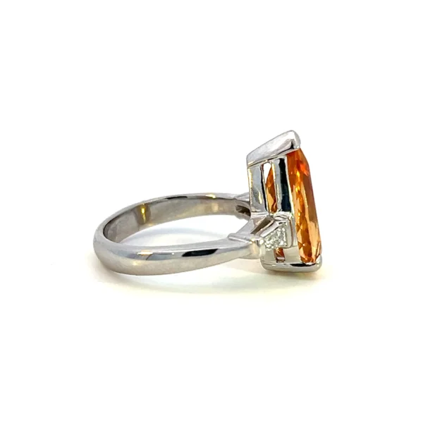 One estate 14 karat white gold pear-shaped faceted orangish yellow topaz weighing 4.85 carats with 2 tapered baguette side diamonds weighing 0.12 carat total weight