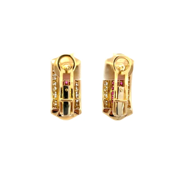 One pair of estate 18 karat yellow gold half-hoop omega back earrings set with 39 French-cut natural rubies in invisible settings in the center of the earrings and 26 round brilliant cut diamonds weighing 0.75 total carat weight set on each edge of the earrings