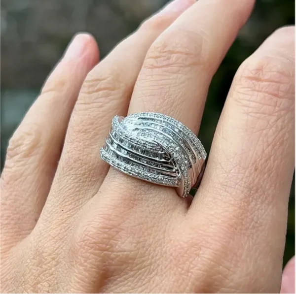 One estate 14 karat white gold interlaced fashion ring with 55 round brilliant diamonds and 108 baguette diamonds with all 163 weighing 1.50 carats total. The ring consists of two wide multi-row lines that curve into one another.