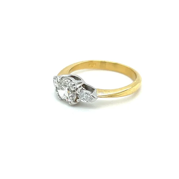 One estate 18 karat two-tone gold three-stone engagement ring with a center old European-cut diamond weighing 1.12 carats and 2 pear-shaped faceted accented diamonds. The diamonds are set in white gold while the polished band is yellow gold