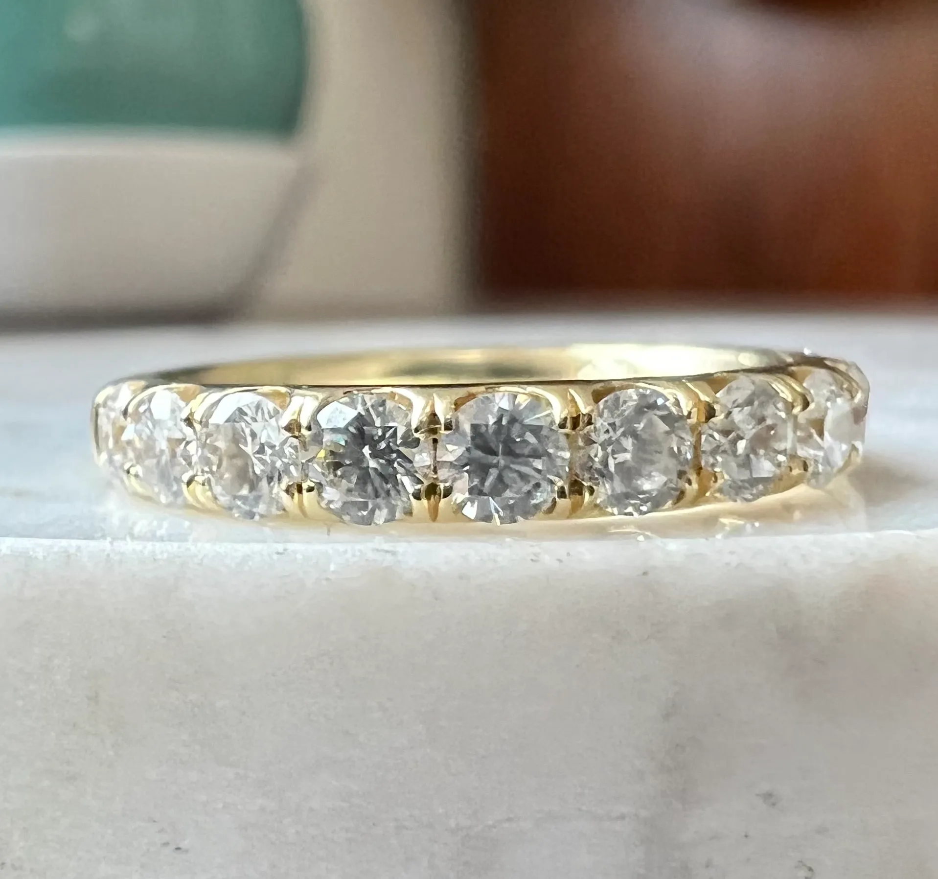 an estate 14 karat yellow gold wedding-style band with 11 round brilliant diamonds weighing 1 carat in prong settings.