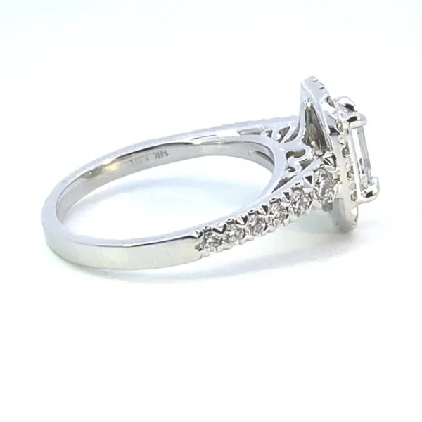 A 14 karat white gold lab-grown diamond engagement ring containing a center emerald-cut diamond and round brilliant accent diamonds in the halo and in the band