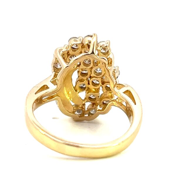 One 14 karat yellow gold diamond cluster ring from the 1980s containing 19 round brilliant diamonds in an asymmetrical cluster design.