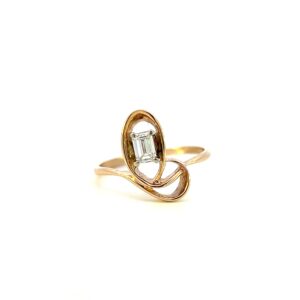 One estate 14 karat yellow gold abstract diamond ring from the 1980s containing an emerald-cut diamond weighing 0.26 carat total weight in an asymmetrical open-loop design.