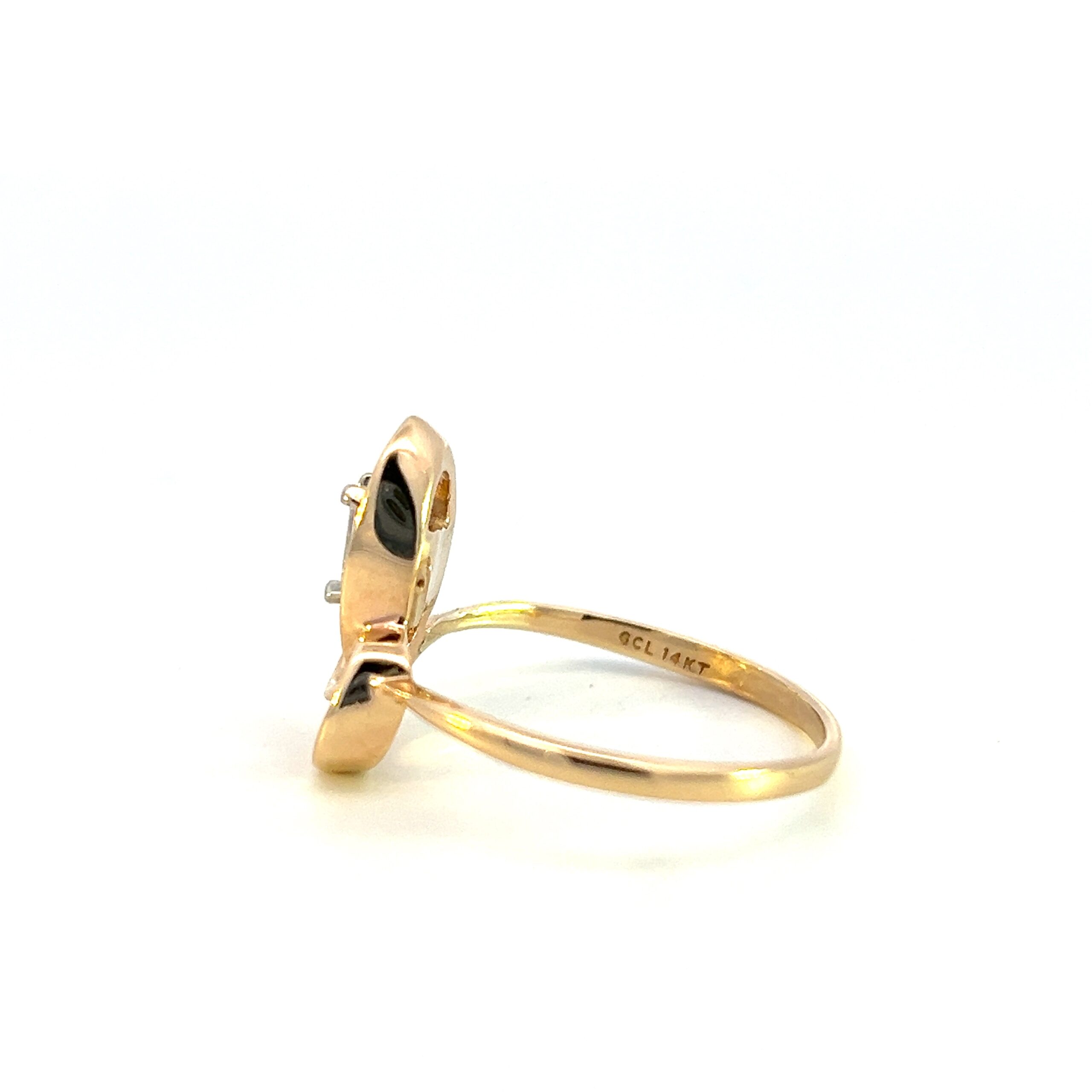 One estate 14 karat yellow gold abstract diamond ring from the 1980s containing an emerald-cut diamond weighing 0.26 carat total weight in an asymmetrical open-loop design.