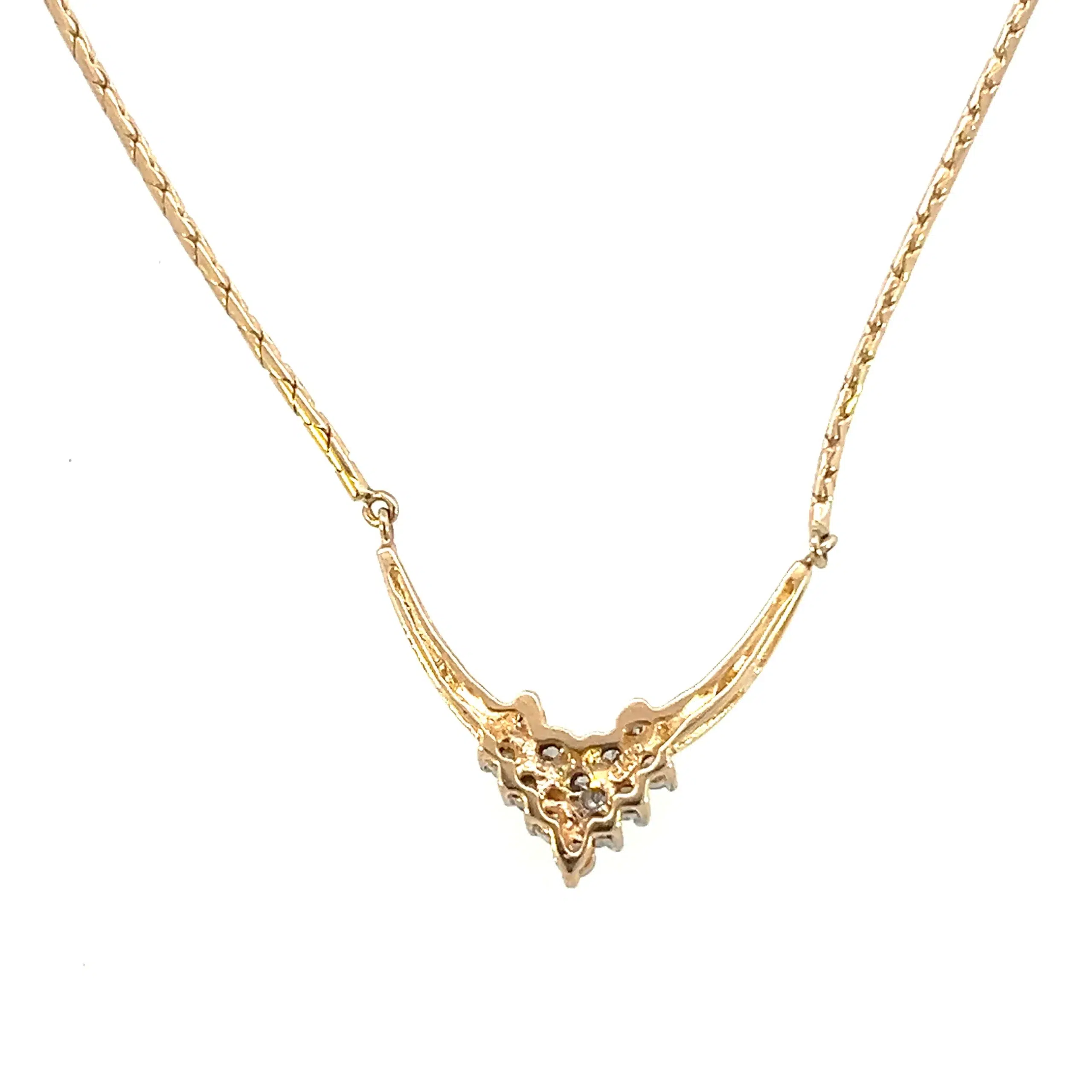 One estate vintage diamond chevron necklace crafted from 14 karat yellow gold and featuring 13 round brilliant diamonds weighing 0.45 carat total weight in a cluster on a pointed chevron pendant. The fixed pendant is attached to a snake link chain. the necklace has a total length of 16" with a lobster claw push pin clasp.
