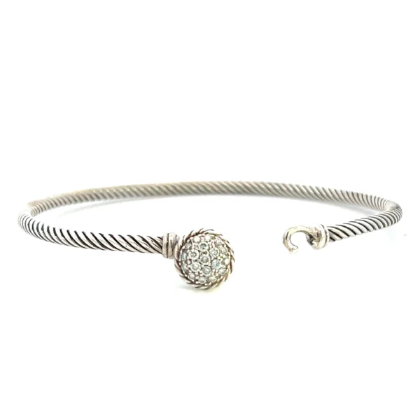 One estate David Yurman Diamond Bracelet containing a round cluster of round diamonds weighing 0.18 carat total weight in pave settings. The round area where the diamonds are set also functions as the clasp of the bracelet. the length of the bracelet is a twisted cable style.