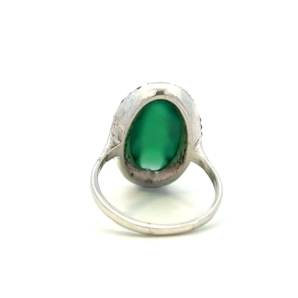 One estate sterling silver ring with an oval cabochon chrysoprase surrounded by a double halo of round-faceted marcasite in pave settings.