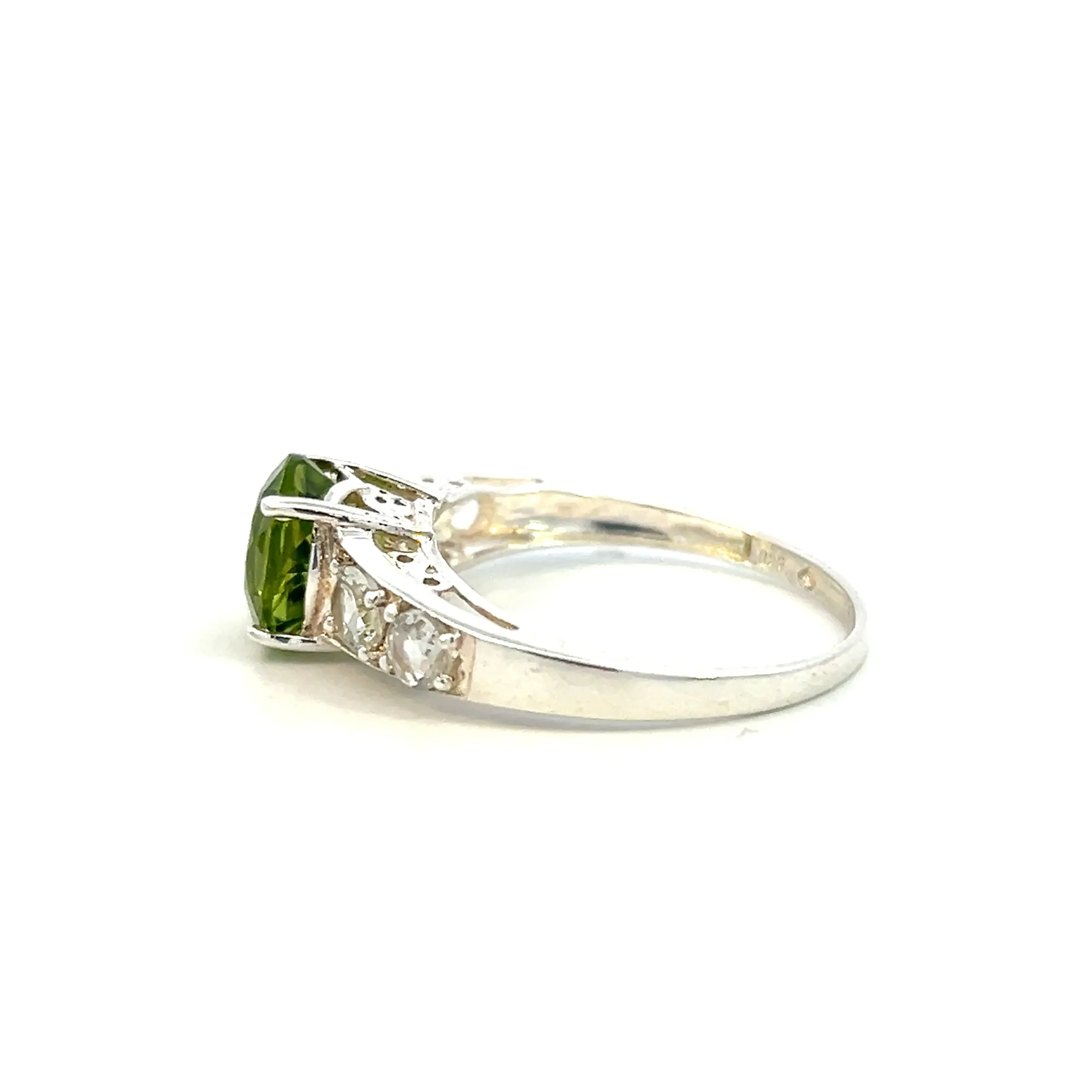One estate sterling silver peridot ring with a round faceted peridot in a four-prong setting and 4 round faceted white quartzes with 2 channel-set in each shoulder of the ring.