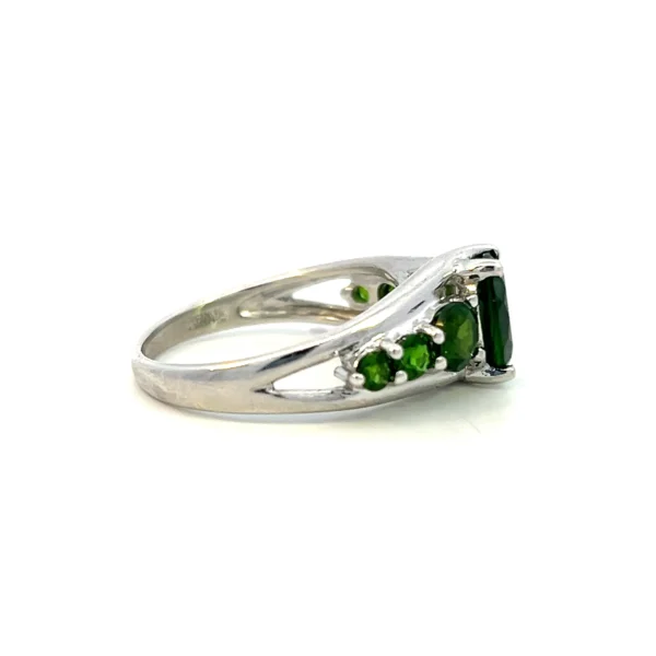 One estate sterling silver quartz ring with a center oval dark green quartz with 3 round dark green quartzes set in each shoulder of the band in graduating sizes.