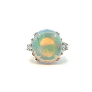 One estate 14 karat white gold opal ring set with a slightly oval mostly round cabochon opal with light blue/green color measuring 15.4x14mm. Each shoulder of the ring features a round brilliant diamond and the ring has a split-shank band.