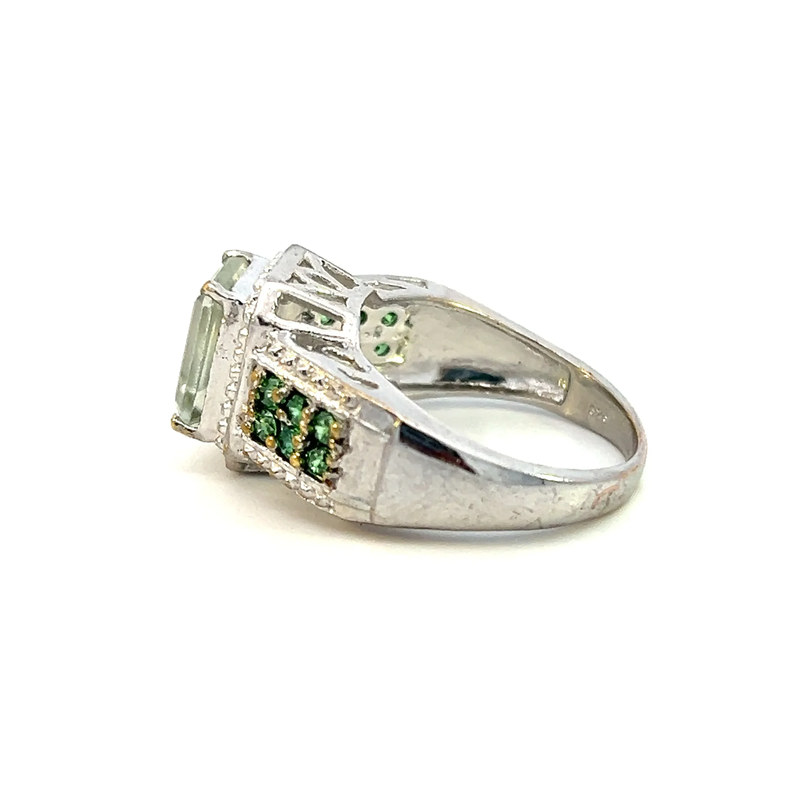 One estate sterling silver green quartz ring featuring emerald-cut green quartz inside a halo of silver bead work. The band features a double row of round green cubic zirconia with silver beadwork also on each edge of the cubic zirconia.