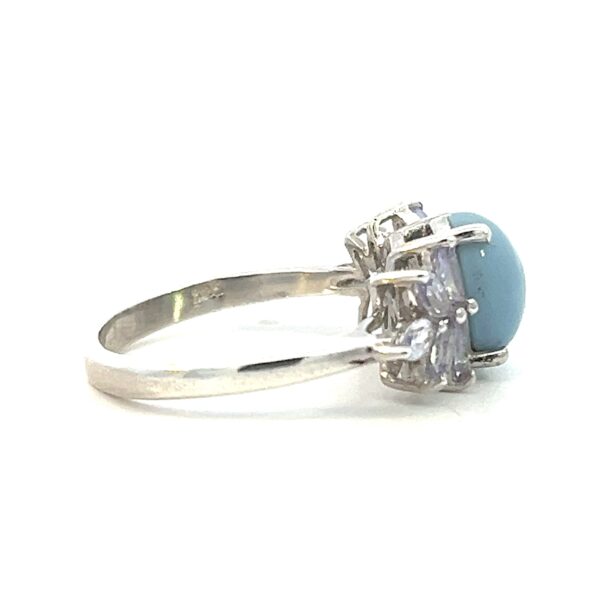 One estate sterling silver gemstone ring containing a center oval cabochon blue chrysoprase and 10 marquise shaped faux tanzanite creating a spray design on either side of the chrysoprase.