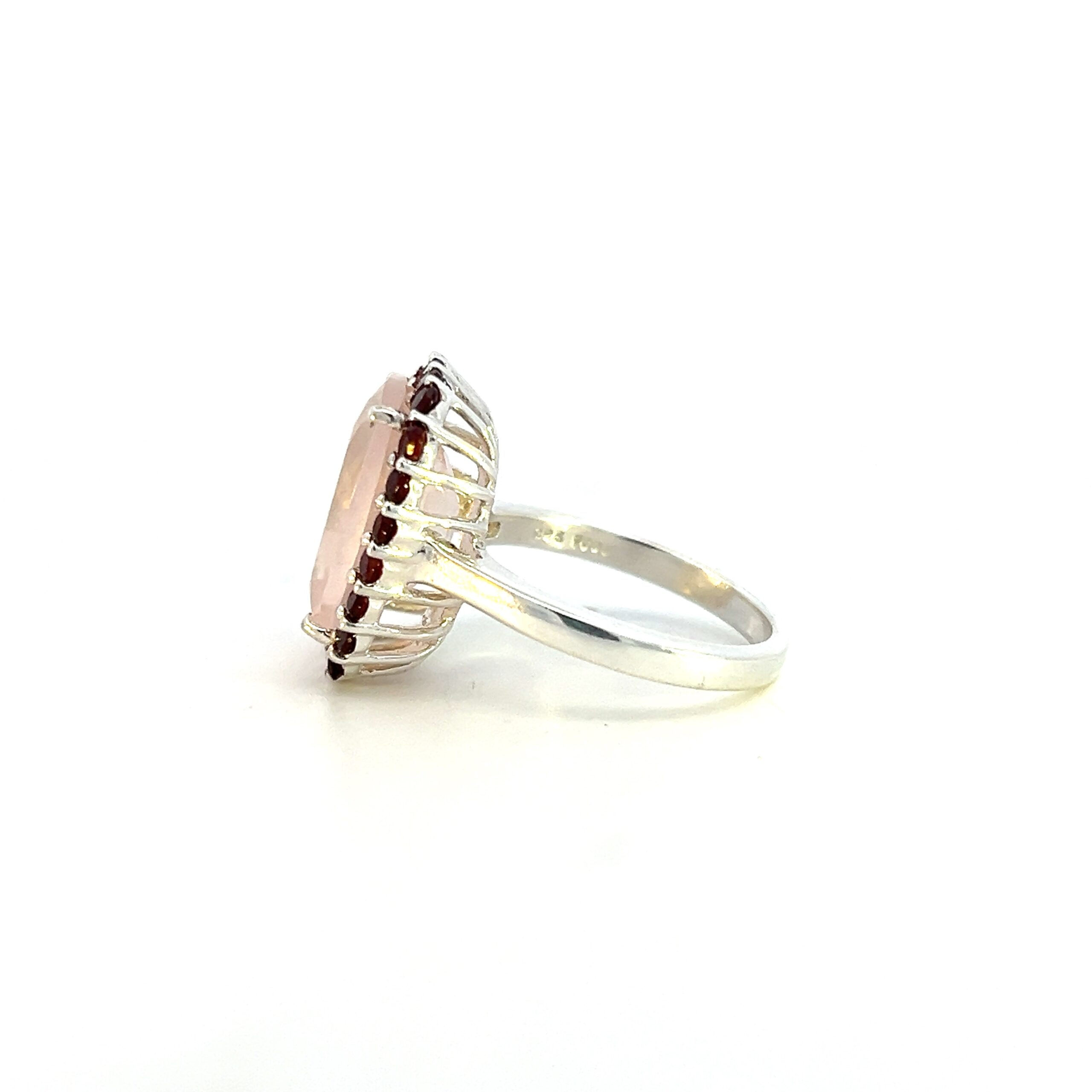 One estate sterling silver rose quartz and garnet ring containing elongated cushion-shaped faceted rose quartz measuring 14x10mm surrounded by a halo of 22 round garnets measuring 2mm each.