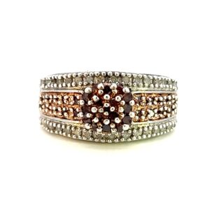 One estate bronze diamond ring crafted from sterling silver containing a center cluster of bronze diamonds in sterling silver pave settings. The band contains four rows with the outer two rows containing round white diamond in pave settings and the inner two rows plated in rose gold and containing bronze diamonds in pave settings.