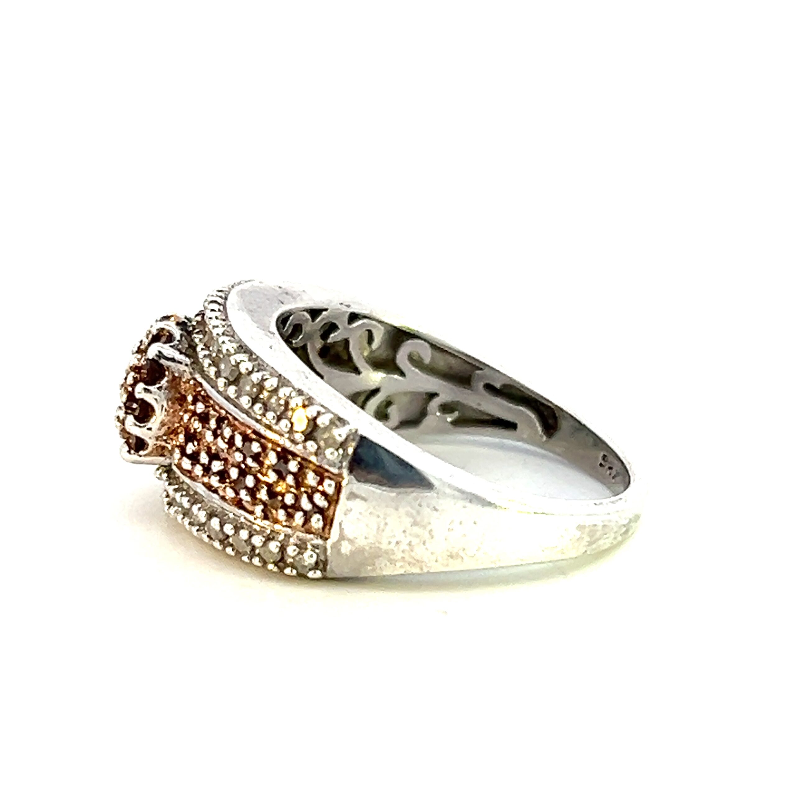 One estate bronze diamond ring crafted from sterling silver containing a center cluster of bronze diamonds in sterling silver pave settings. The band contains four rows with the outer two rows containing round white diamond in pave settings and the inner two rows plated in rose gold and containing bronze diamonds in pave settings.