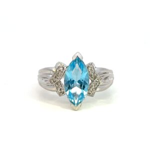 One estate blue topaz and diamond ring crafted from 10 karat white gold with a center marquise blue topaz measuring 13x6mm and 10 round brilliant diamonds set in the band in an "X" design that appears to cradle the center topaz.