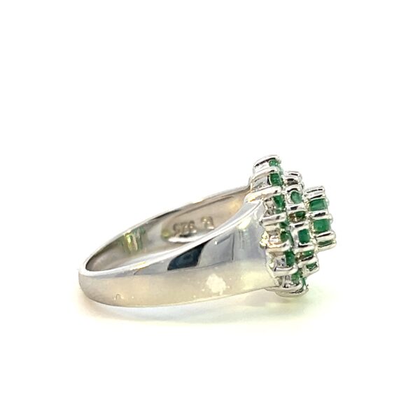 One estate emerald cluster ring crafted from sterling silver containing a center 4mm round emerald and 24 1mm round emeralds in two halos around the center emerald.