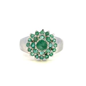 One estate emerald cluster ring crafted from sterling silver containing a center 4mm round emerald and 24 1mm round emeralds in two halos around the center emerald.