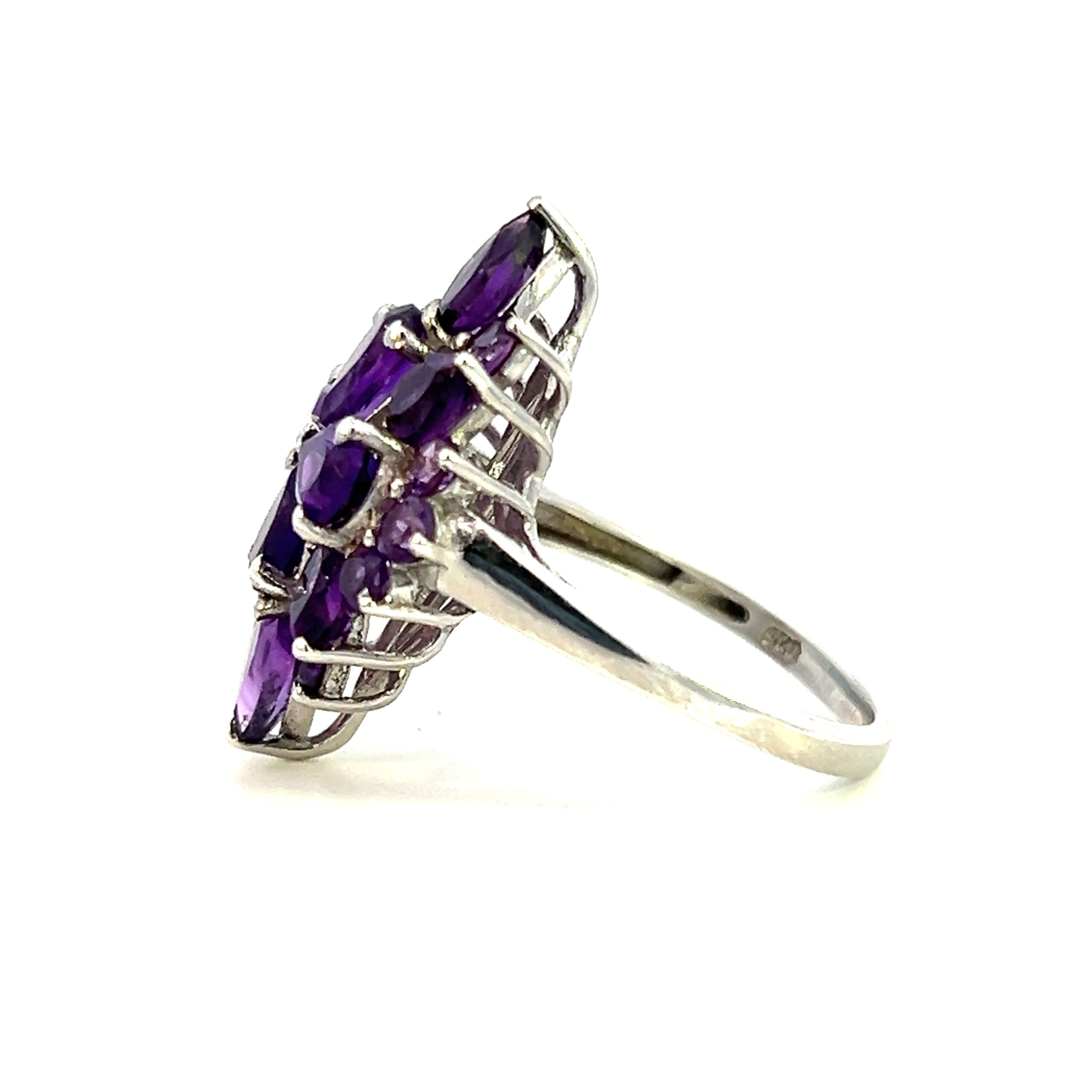 One estate sterling silver amethyst ring containing faceted amethysts in round and pear shapes creating an elongated flower design with points to the north and south.