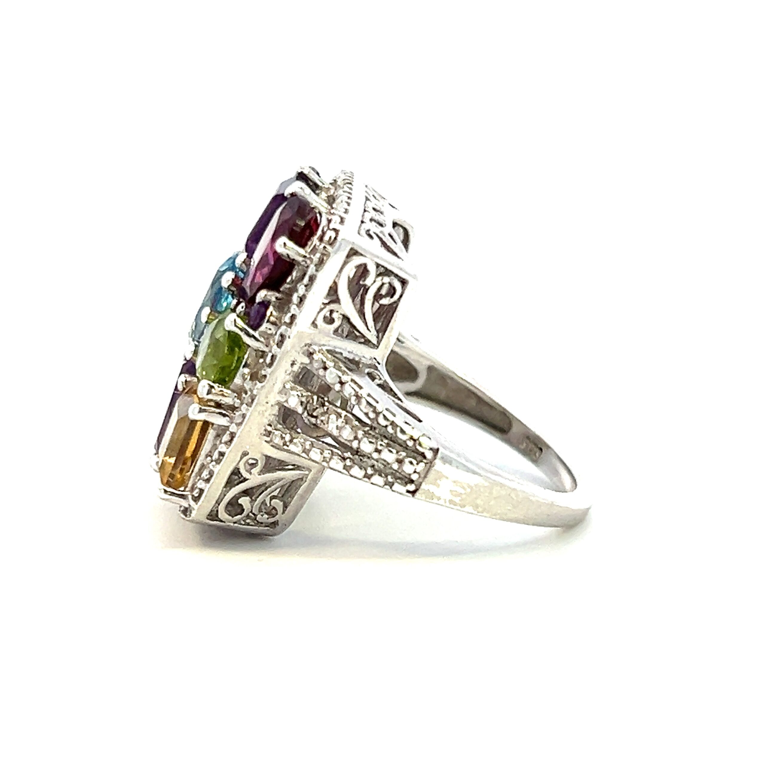 The Estate Quilted Rainbow Gemstone Ring is crafted from sterling silver and features a square top set with various gemstones in a variety of colors and shapes resembling a patchwork quilt.