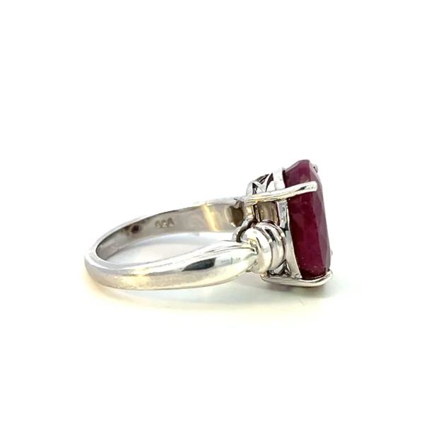 Estate sterling silver ring with an oval-shaped faceted lab-created ruby and fluted accents.