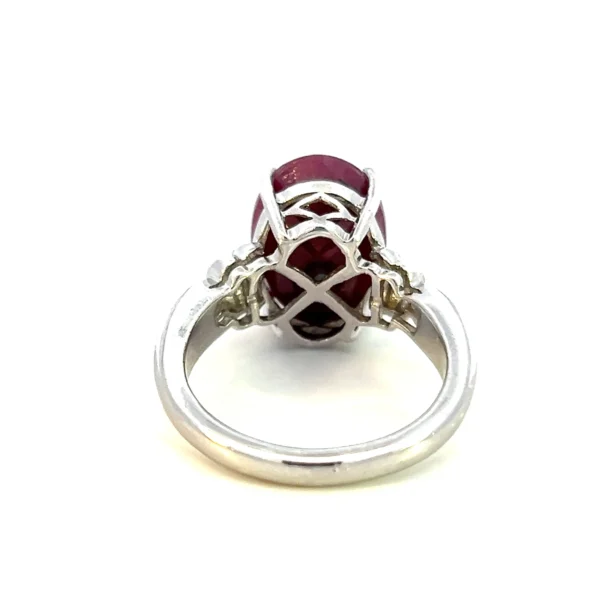 Estate sterling silver ring with an oval-shaped faceted lab-created ruby and fluted accents.