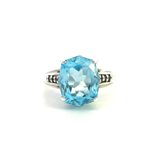 One estate sterling silver ring with a center 12x10mm oval light blue topaz and 6 round white sapphires measuring 1.5mm each bead-set in the band.