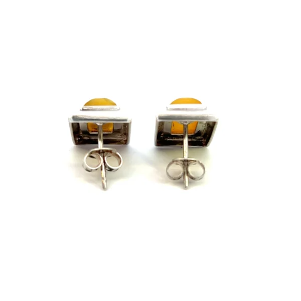 One estate pair of sterling silver rectangle-shaped stud earrings each bezel-set with a rectangle-shaped cabochon Baltic amber.