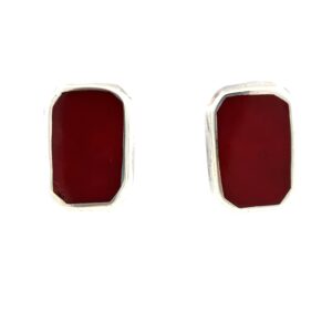 One estate pair of sterling silver stud earrings an emerald shape with smooth crimson red resin in a polished bezel setting. The earrings are secured with omega back closures.