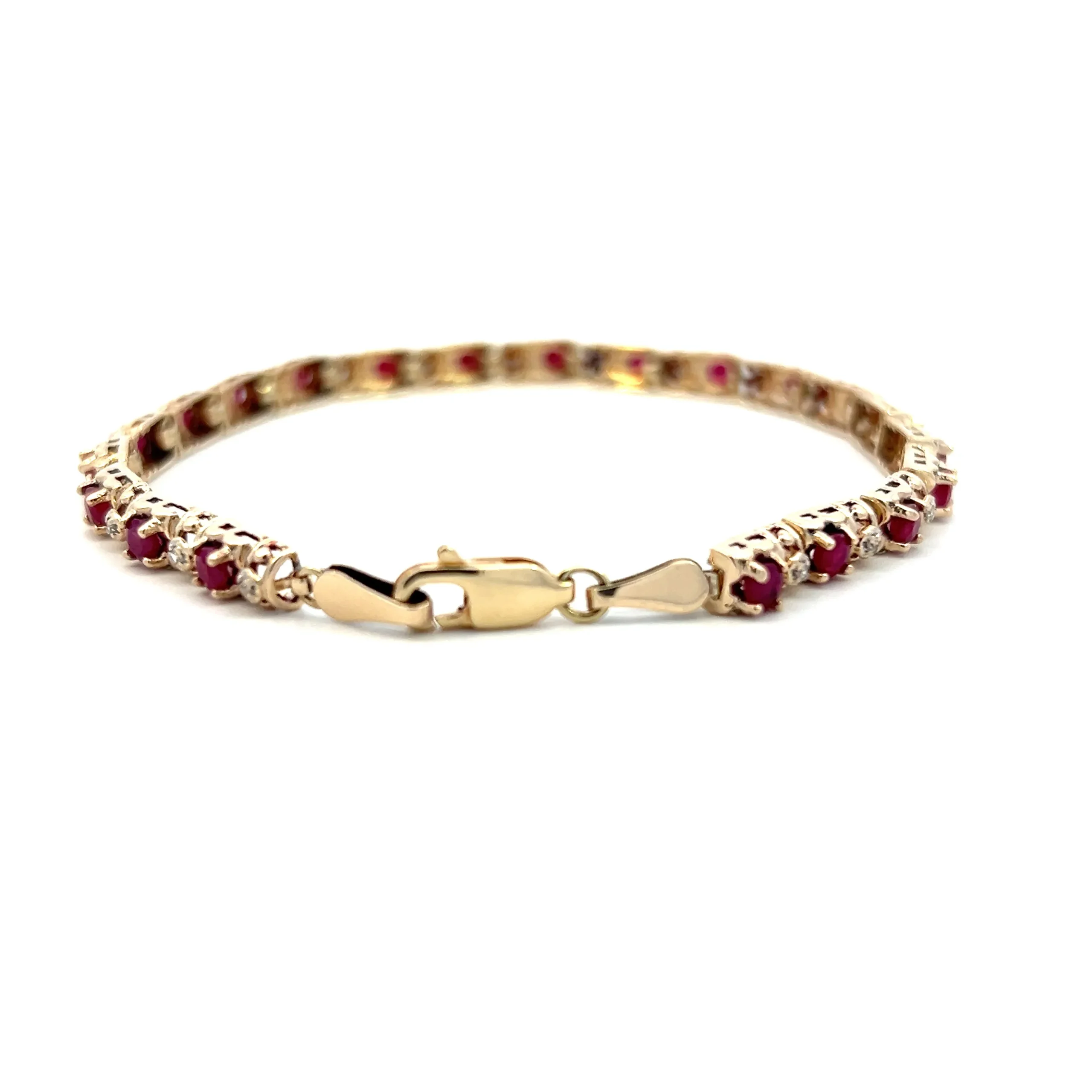 One estate 10 karat yellow gold ruby and diamond tennis bracelet with alternating between 21 round rubies measuring 2.80mm each and 21 round brilliant diamonds weighing 0.15 carat total weight. The bracelet measures 7" long with a lobster claw clasp.