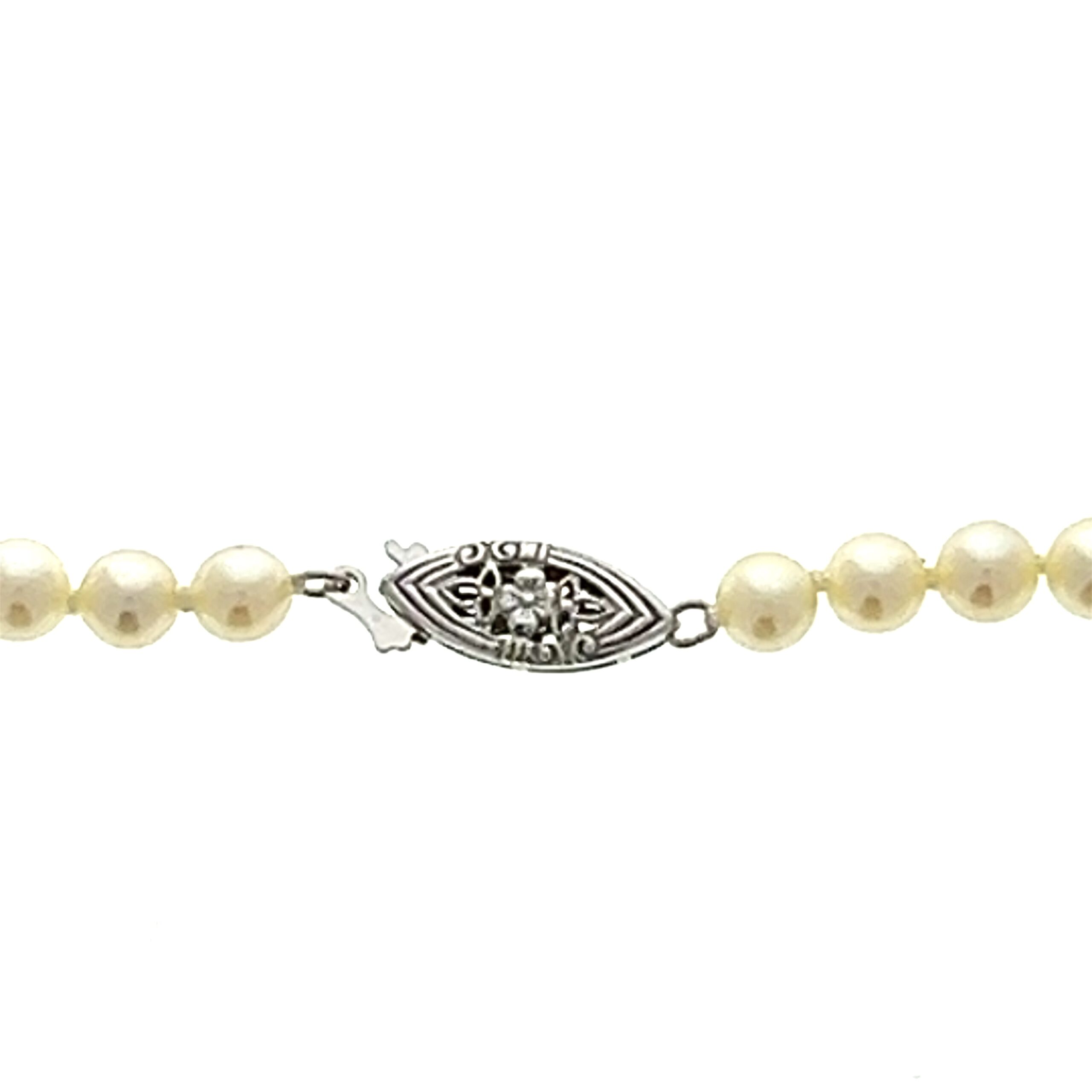 One estate vintage pearl strand necklace featuring cream colored cultured pearls ranging in size 4.5mm to 7.7mm in a graduated design. The necklace measures 17" long and has a 14 karat white gold clasp.