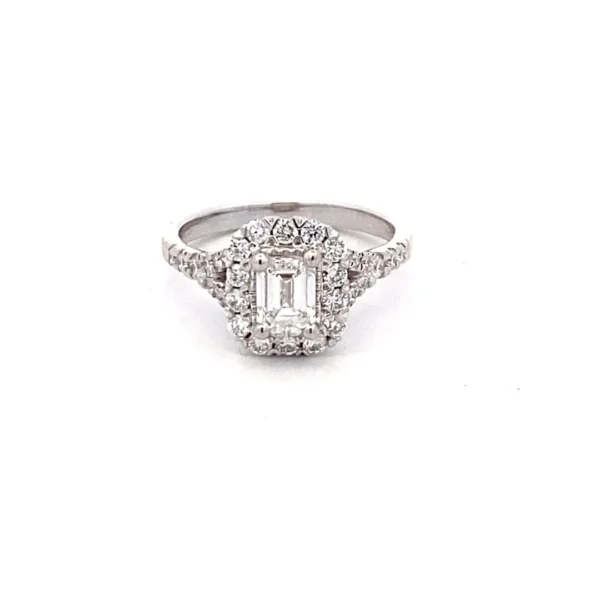A 14 karat white gold lab-grown diamond engagement ring containing a center emerald-cut diamond and round brilliant accent diamonds in the halo and in the band