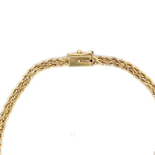 One estate 14 karat yellow gold double rope chain bracelet with 3 round brilliant diamonds weighing 0.05 carat total weight. The bracelet measures 7" long and is secured with a hidden box clasp and a figure-eight safety catch.