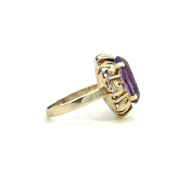 One estate 8 karat yellow gold gemstone ring containing one oval faceted amethyst weighing 9.62 carats in a four-prong setting surrounded by an open-work gold frame. Stamped "333 801" with a total weight of 4.30 grams. Vintage from the 1960s. Size 5.75.