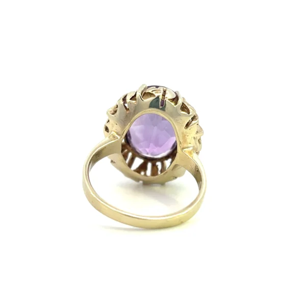 One estate 8 karat yellow gold gemstone ring containing one oval faceted amethyst weighing 9.62 carats in a four-prong setting surrounded by an open-work gold frame. Stamped "333 801" with a total weight of 4.30 grams. Vintage from the 1960s. Size 5.75.