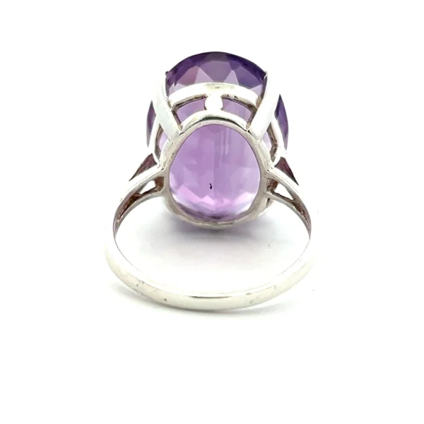 One estate sterling silver solitaire ring containing one oval-shaped faceted amethyst weighing 0.38 carat in a four-prong setting.