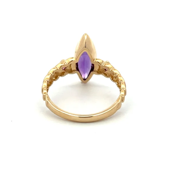 One estate contemporary 14 karat yellow gold amethyst ring with a center marquise-shaped faceted amethyst weighing 1.01 carats in a bezel setting and a square cushion-shaped faceted amethyst on either side in the shoulders in a diamond-oriented bezel setting. Half of the band features a cascading spade shape.