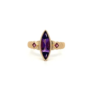 One estate contemporary 14 karat yellow gold amethyst ring with a center marquise-shaped faceted amethyst weighing 1.01 carats in a bezel setting and a square cushion-shaped faceted amethyst on either side in the shoulders in a diamond-oriented bezel setting. Half of the band features a cascading spade shape.