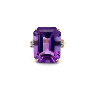 One estate 14 karat yellow gold amethyst and diamond ring with an emerald-cut amethyst measuring 16.60x12.30mm and weighing 10.97 carats in a four-prong setting accented by 4 round brilliant diamonds weighing 0.07 carat total weight with 2 diamonds set in each shoulder of the band. The band measures 2.2mm wide.