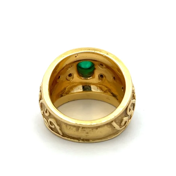 One estate 8 karat yellow gold emerald and diamond ring set with one (1) oval cabochon emerald weighing approximately 0.95 carat and eight (8) round brilliant diamonds weighing 0.30 total carat weight with matching J color and I1/2 clarity. The band is wide and tapers as it goes to the back. The band has a sandblasted finish and raised polished elements including a line along the top and bottom, scroll elements, and the bezel settings for the center emerald and the diamonds. The stones go approximately halfway around the band while the scroll elements go almost entirely around the band.