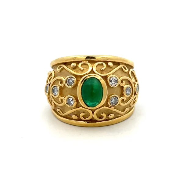 One estate 8 karat yellow gold emerald and diamond ring set with one (1) oval cabochon emerald weighing approximately 0.95 carat and eight (8) round brilliant diamonds weighing 0.30 total carat weight with matching J color and I1/2 clarity. The band is wide and tapers as it goes to the back. The band has a sandblasted finish and raised polished elements including a line along the top and bottom, scroll elements, and the bezel settings for the center emerald and the diamonds. The stones go approximately halfway around the band while the scroll elements go almost entirely around the band.