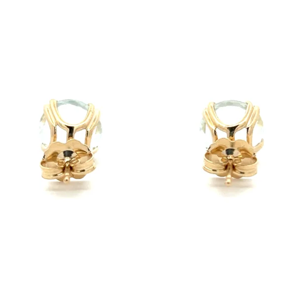 One estate pair of 14 karat yellow gold stud earrings containing round-faceted aquamarines weighing 3.25 carats total weight in double four-prong basket settings with friction posts and backs