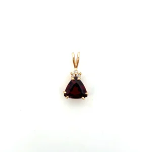 One estate 14 karat yellow gold pendant with a trillion-cut garnet weighing 2.49 carats and 3 round brilliant diamonds weighing 0.05 carat total weight clustered at the top of the garnet. the pendant has a rabbit-ear bail.