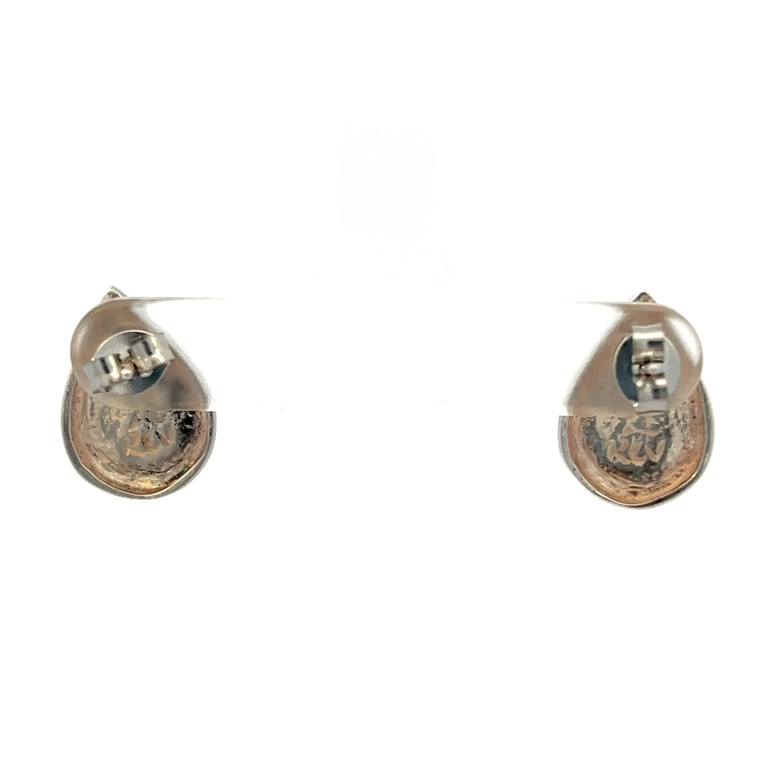 One estate pair of sterling silver pear-shaped stud earrings with an interior pear shape with yellow gold plating. The exterior pear-shaped band is sterling silver and the bottom half has geometrical etched designs. Stamped 925. total weight 2.51 grams. Friction posts and backs. 