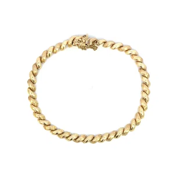 One estate 14 karat yellow gold bracelet with macaroni links that alternate between textured and polished finish. The bracelet measures 7.5" long and is secured with a box clasp with a figure-eight safety catch and a 2.5" safety chain.