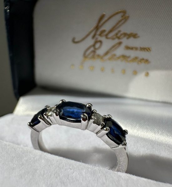 A finished custom design band with blue sapphires and diamonds